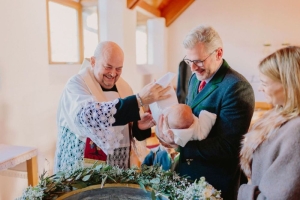 Taufe mit Pfarrer und Taufpaten